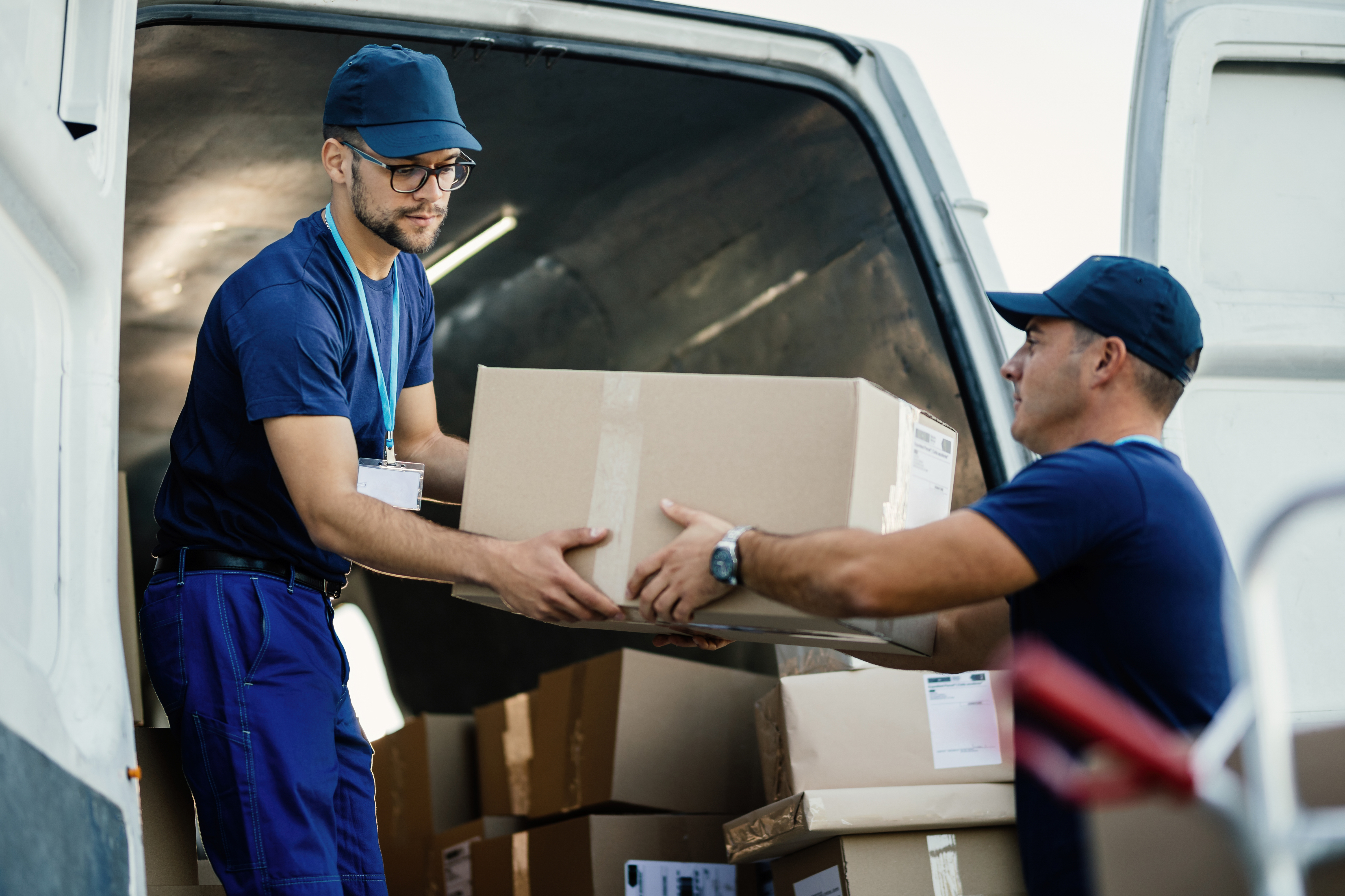 Movers loading boxes into the back of a van